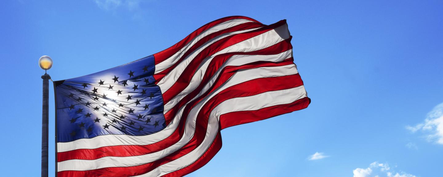 american flag blowing blue sky  